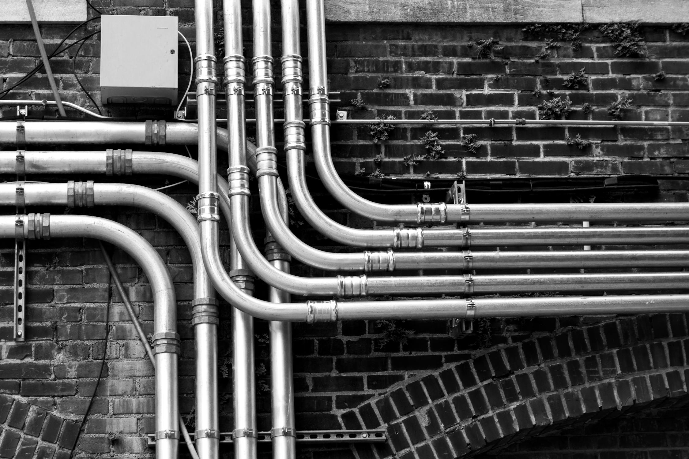 Pipelines mounted on a wall, showcasing the expertise of the premier plumbing company in installation and maintenance.