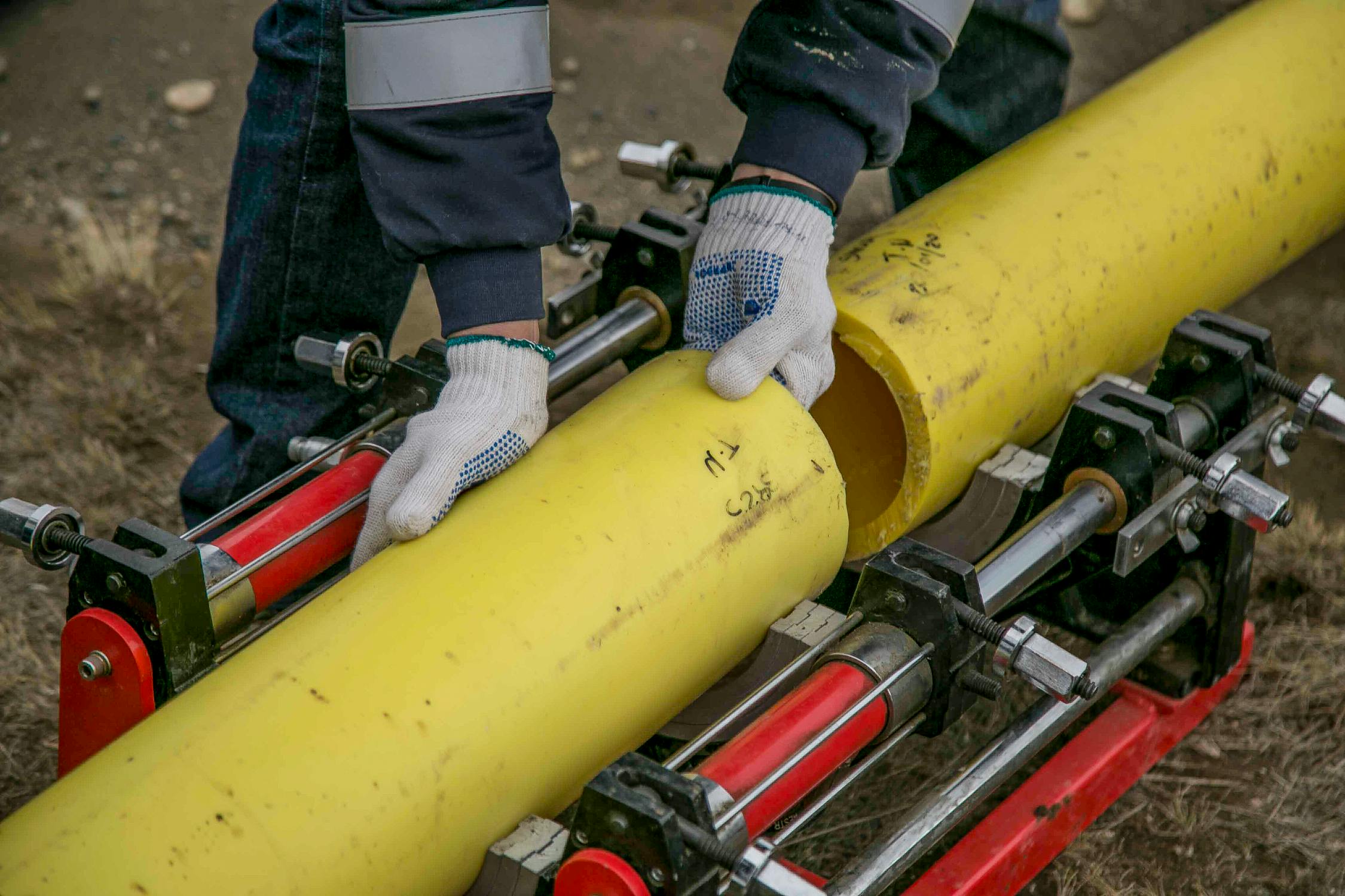 A person holding yellow pipes, representing the quality and reliability of plumbing services.